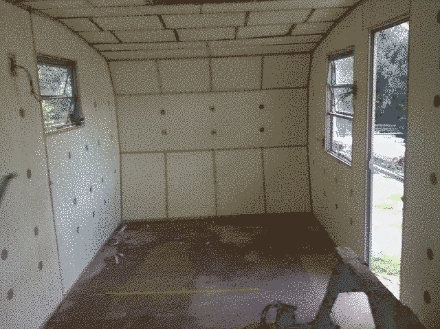 Back of the caravan, insulated. a lot of rectangular panels edged with wood.