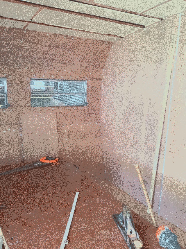 corner of the caravan showing the walls lined with ply and the ceiling still just insulation.